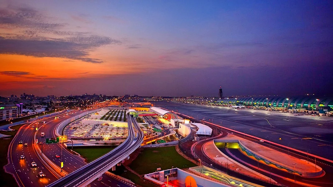 Landscape view of Dubai Terminal 3 as the sun sets with an orange and blue sky